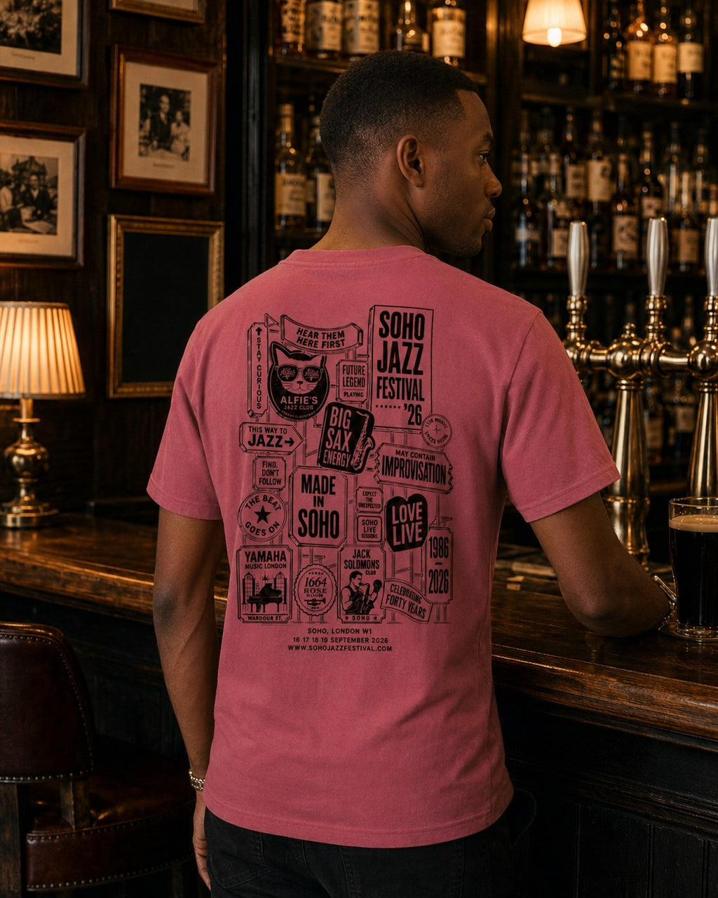 The '26 Tee in watermelon, back print of the Soho Jazz Festival sign stack, worn at a Soho bar